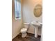 Stylish half bathroom with pedestal sink, oval mirror, and wood-look flooring at 60 Sonoma Drive, Dallas, GA 30157