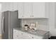 Bright kitchen shows granite counters, tile backsplash, stainless steel refrigerator, and white cabinets at 6005 Pine Bluff Pl, Conyers, GA 30013