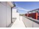 A modern exterior balcony with a black metal railing and white concrete flooring under a blue sky at 1145 Kirkwood Se Ave # 14, Atlanta, GA 30316