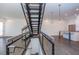 Open-concept staircase with metal railings connecting living spaces and kitchen with island at 1145 Kirkwood Se Ave # 14, Atlanta, GA 30316