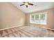 Neutral bedroom with a ceiling fan and a large window letting in natural light at 2995 Belshire Trl, Dacula, GA 30019