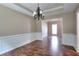 Elegant dining room features hardwood floors, tray ceilings, chandelier and decorative wainscoting at 2995 Belshire Trl, Dacula, GA 30019