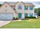 Charming two-story home boasts a well-manicured lawn, bright blue door, and matching shutters at 2995 Belshire Trl, Dacula, GA 30019