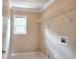 Bright laundry room with a window, patterned floor and a white wire storage shelf at 2995 Belshire Trl, Dacula, GA 30019
