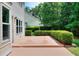 Back patio with a manicured hedge and access to the home's interior at 2995 Belshire Trl, Dacula, GA 30019