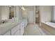 Well-lit bathroom with dual sinks, shower, soaking tub, and neutral color scheme at 415 Winn Park Ct, Roswell, GA 30075