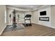 Spacious exercise room with a modern fireplace and hardwood flooring at 415 Winn Park Ct, Roswell, GA 30075