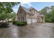 Side view of a brick home featuring a spacious three-car garage and well-maintained landscaping at 415 Winn Park Ct, Roswell, GA 30075