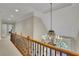 Elegant hallway with chandelier, railing, and abundant light at 415 Winn Park Ct, Roswell, GA 30075