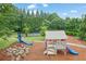 Community playground with slides, playhouse, basketball court, and woodchip groundcover at 415 Winn Park Ct, Roswell, GA 30075