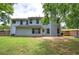 Rear view of the home showing the patio and a lush green lawn and mature trees at 4975 Rockstone Way, Acworth, GA 30101