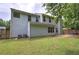 View of the home's light blue back exterior with lush green yard and mature trees at 4975 Rockstone Way, Acworth, GA 30101