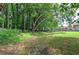 Expansive grassy backyard with a wood fence and mature trees, perfect for outdoor activities and privacy at 4975 Rockstone Way, Acworth, GA 30101
