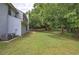 Large backyard with lush green grass, mature trees, and an AC unit near the back of the house at 4975 Rockstone Way, Acworth, GA 30101