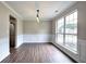 Dining room featuring a large window, modern lighting, and dark wood-look floors, adjacent to the kitchen at 4975 Rockstone Way, Acworth, GA 30101