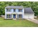 Beautiful two-story home with light blue siding, blue shutters, a well-manicured lawn and two car garage at 4975 Rockstone Way, Acworth, GA 30101