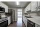 Modern kitchen with stainless steel appliances, white cabinets, and a view into the dining room at 4975 Rockstone Way, Acworth, GA 30101