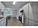 Efficient kitchen layout with stainless steel appliances, white cabinetry, and views to the dining area and backyard at 4975 Rockstone Way, Acworth, GA 30101