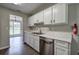 Functional kitchen featuring white cabinets, stainless steel appliances, and marble countertops with a view to the dining area at 4975 Rockstone Way, Acworth, GA 30101