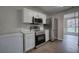 Well-equipped kitchen with stainless steel appliances, white cabinets, and a view to the dining area at 4975 Rockstone Way, Acworth, GA 30101