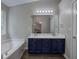 Bathroom featuring a soaking tub, double sink vanity, updated lighting, and neutral paint throughout at 4975 Rockstone Way, Acworth, GA 30101