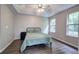 Light-filled main bedroom with ceiling fan, neutral paint, and large windows with treed view at 4975 Rockstone Way, Acworth, GA 30101