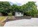 Backyard featuring a new shed, garden beds, mulch, and a large concrete patio at 1186 Hawthorn Ln, Grayson, GA 30017