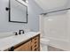Bright bathroom features a wooden vanity, modern fixtures, and tub with shower head at 1186 Hawthorn Ln, Grayson, GA 30017