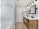Bathroom featuring a modern dual vanity with two mirrors and a built-in tub at 1186 Hawthorn Ln, Grayson, GA 30017