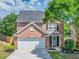 Beautiful two-story brick home with a manicured lawn, lovely landscaping, and an attached garage at 1186 Hawthorn Ln, Grayson, GA 30017