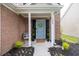 Inviting front porch with a blue door, decorative wreath, and potted greenery creating a welcoming entry at 1186 Hawthorn Ln, Grayson, GA 30017
