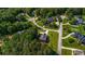 An aerial view showcases a home in a verdant, suburban neighborhood with winding streets and mature trees at 125 Legacy Way, Oxford, GA 30054