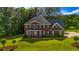 Beautiful two-story brick home featuring a manicured lawn and mature trees at 125 Legacy Way, Oxford, GA 30054