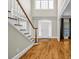 Bright foyer with hardwood floors, staircase, and front door with transom window at 125 Legacy Way, Oxford, GA 30054