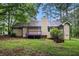 View of the backyard with a purple deck connected to a tan home surrounded by trees at 273 Apalachee Church Rd, Auburn, GA 30011