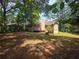 View of the home's backyard with wooden deck painted purple with trees in the background at 273 Apalachee Church Rd, Auburn, GA 30011