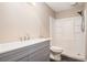 Bathroom featuring a modern gray vanity, shower with white surround, and toilet at 273 Apalachee Church Rd, Auburn, GA 30011
