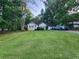 Quaint home featuring green lawn, mature trees, complementary green trim, and an attached two-car garage at 273 Apalachee Church Rd, Auburn, GA 30011
