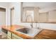 Kitchen sink with butcher block counters and stainless steel faucet, next to the dishwasher and cabinets at 273 Apalachee Church Rd, Auburn, GA 30011