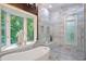 This luxurious bathroom features a soaking tub and walk-in shower with marble surround at 5145 Saddlebred Ln, Cumming, GA 30028