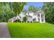 Stately white home with a grand entrance and a beautifully landscaped lawn at 5145 Saddlebred Ln, Cumming, GA 30028
