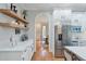 White kitchen adjacent to the dining room, featuring stainless steel refrigerator and open shelving at 5145 Saddlebred Ln, Cumming, GA 30028
