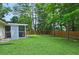 Manicured backyard with mature trees and a wood fence around the perimeter at 2405 Ingram Rd, Duluth, GA 30096