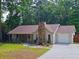 Charming ranch-style home featuring stone accents, a well-maintained lawn, and attached garage at 2405 Ingram Rd, Duluth, GA 30096