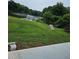 View of a grassy backyard sloping down towards a lake at 2752 Inverloch Cir, Duluth, GA 30096