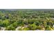 Expansive aerial view of a neighborhood with mature trees and well-maintained homes surrounded by lush greenery at 225 Carriage Station Cir, Roswell, GA 30075