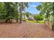 Spacious backyard has a fire pit surrounded by mature shade trees for privacy at 225 Carriage Station Cir, Roswell, GA 30075