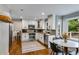 Bright kitchen features white cabinets, stainless steel appliances, granite countertops, and hardwood floors at 225 Carriage Station Cir, Roswell, GA 30075
