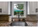 Close-up on the kitchen sink with a window view and granite countertops at 225 Carriage Station Cir, Roswell, GA 30075