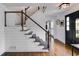 Elegant staircase featuring hardwood steps, white risers, a modern cable railing, and shiplap accents at 225 Carriage Station Cir, Roswell, GA 30075